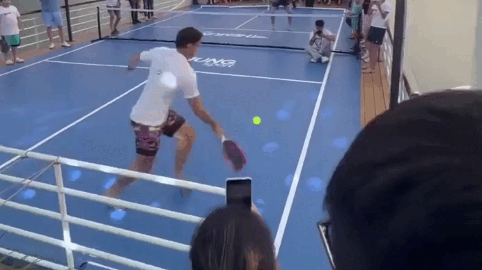 Người đàn ông mặc áo trắng sau khi đỡ quả bóng pickleball đã lao ra ngoài lan can tàu.