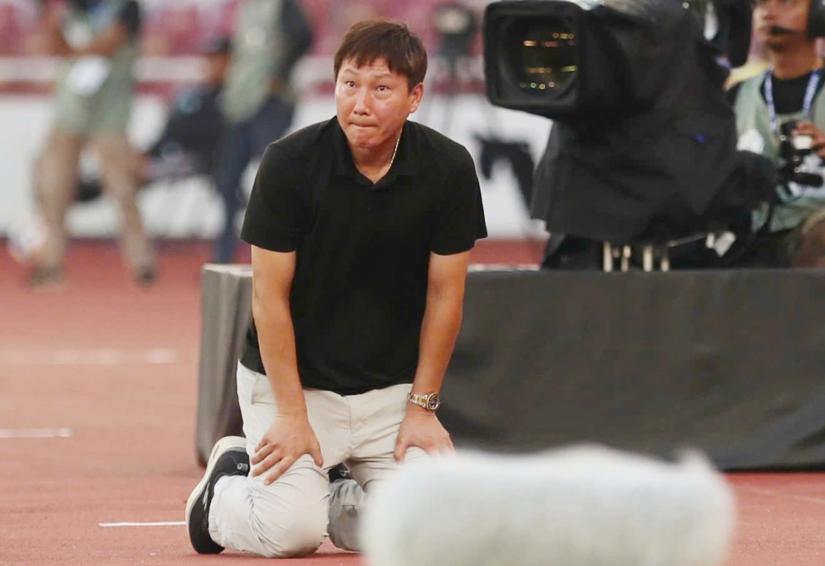 Hình ảnh HLV Kim Sang Sik quỳ gối bên đường biên.