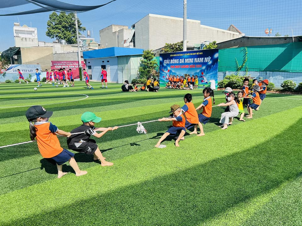 Các bé tham gia trò chơi kéo co tại sân vận động, giúp tăng cường thể chất, tinh thần đồng đội và niềm vui trong các hoạt động ngoài trời.